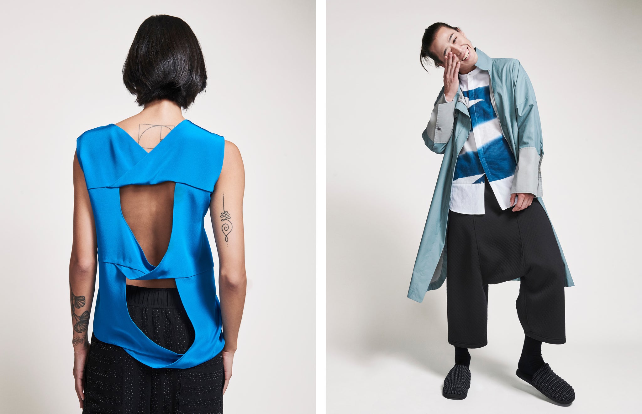 Back shot of draped blue silk top on female model on the left, laughing male model in slate green coat and black drop crotch pants on the right