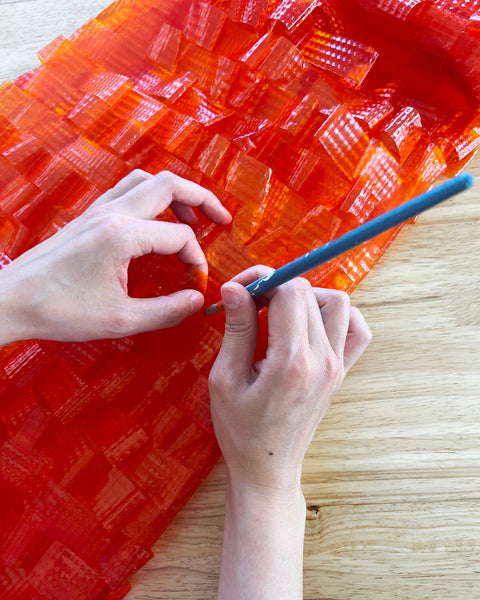 Red-orange bioplastic loops glued by hand