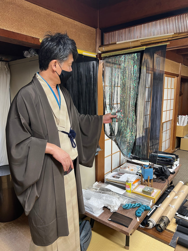 Kyoji Tamiya shows hanging iridescent sliced washi, ready for weaving.