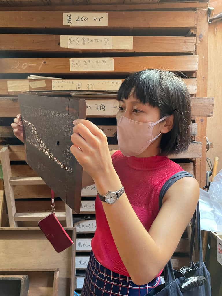 Designer Jenny Lai observing a narrow stencil at Tomita dye Crafts archive