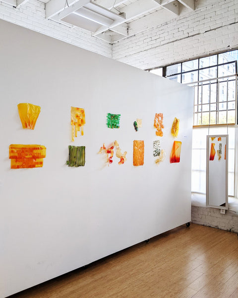 Various swatches of bioplastic techniques developed displayed on wall