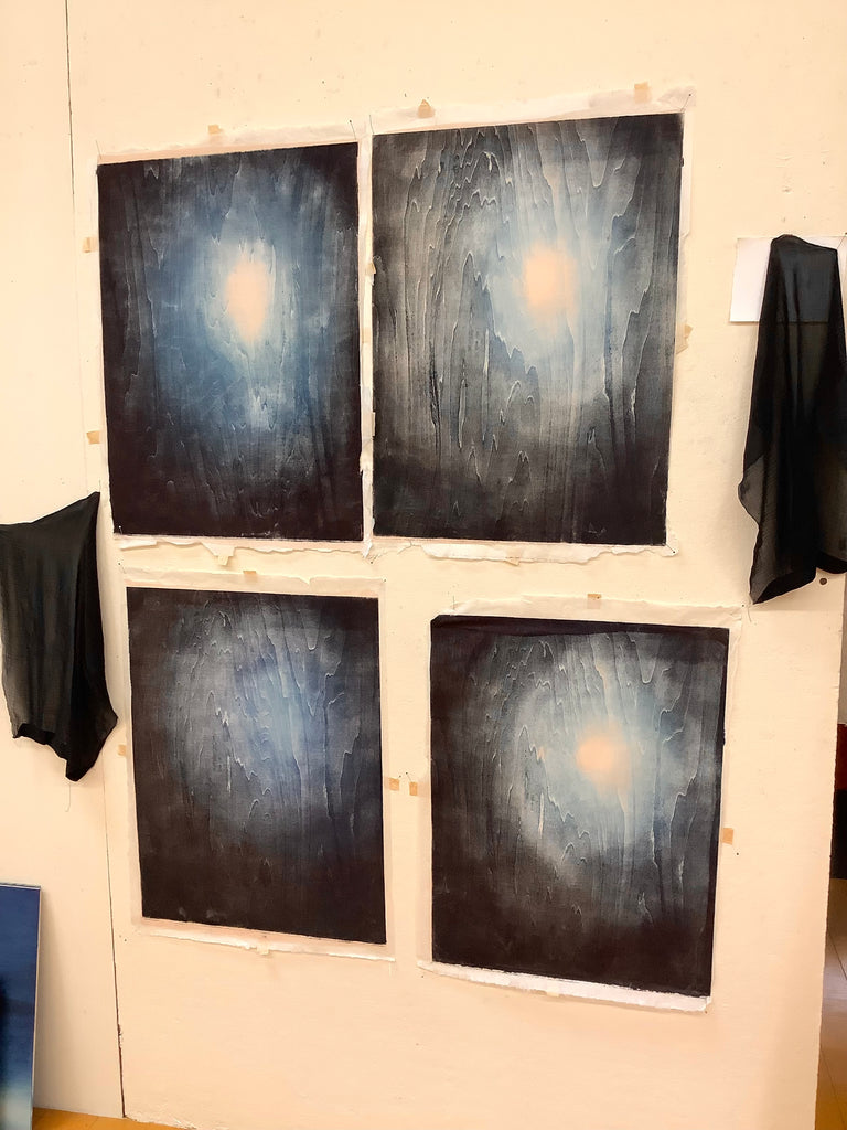 Four blue woodblock variants printed on fabric hanging on a wall