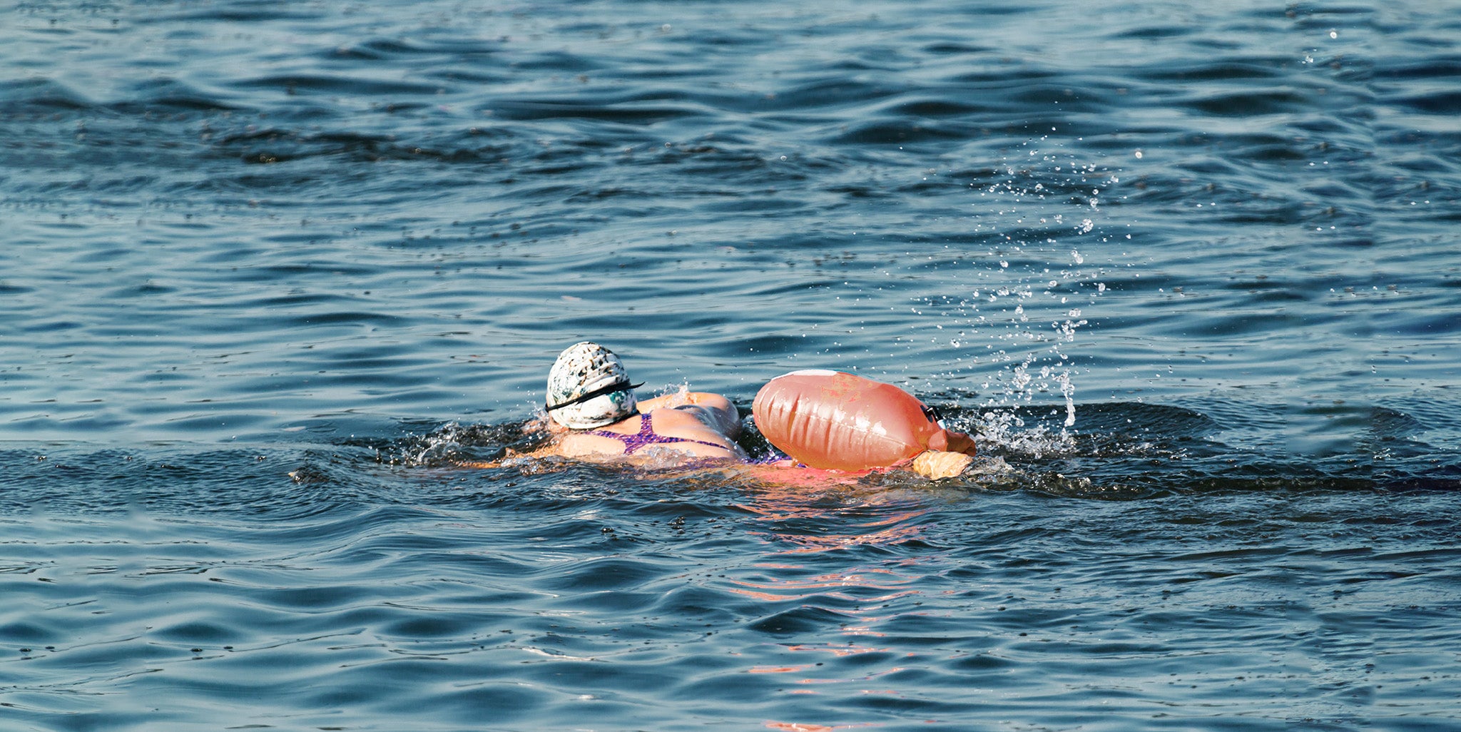 Woman swimming in open water with Pool Buoy