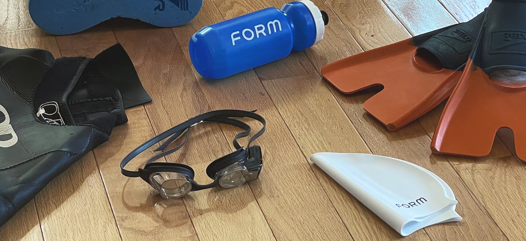 Swimming essentials such as Form swim goggles, swim cap, flippers/fins, and a water bottle