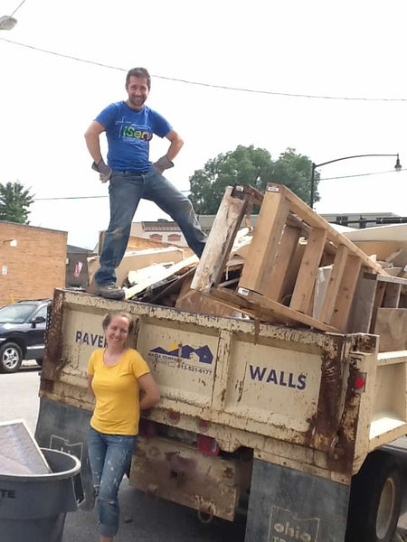 Justin and Emily Carabello load up a dump truck during demo
