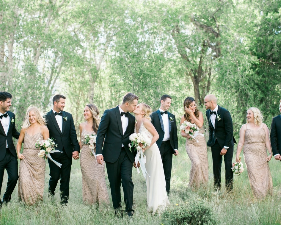 bridal party in black suits and gold bridesmaid dresses 
