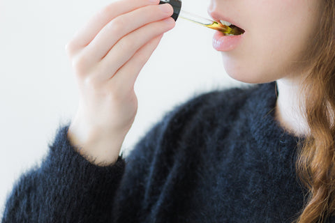 Woman Taking CBD Oil Under Tongue