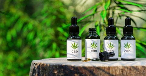 bottles of CBD oil on a tree trunk