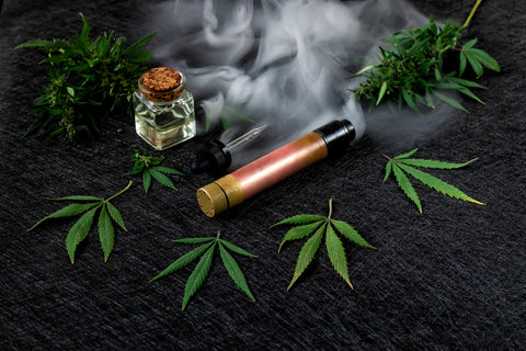 Cannabis liquid. Vape CBD or THC, Vaping Marijuana and Hemp. Against a Dark Background. Thick steam.