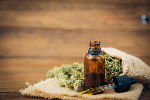 Essential oil made from medicinal cannabis. Buds. Skunk. Marijuana on wooden background 