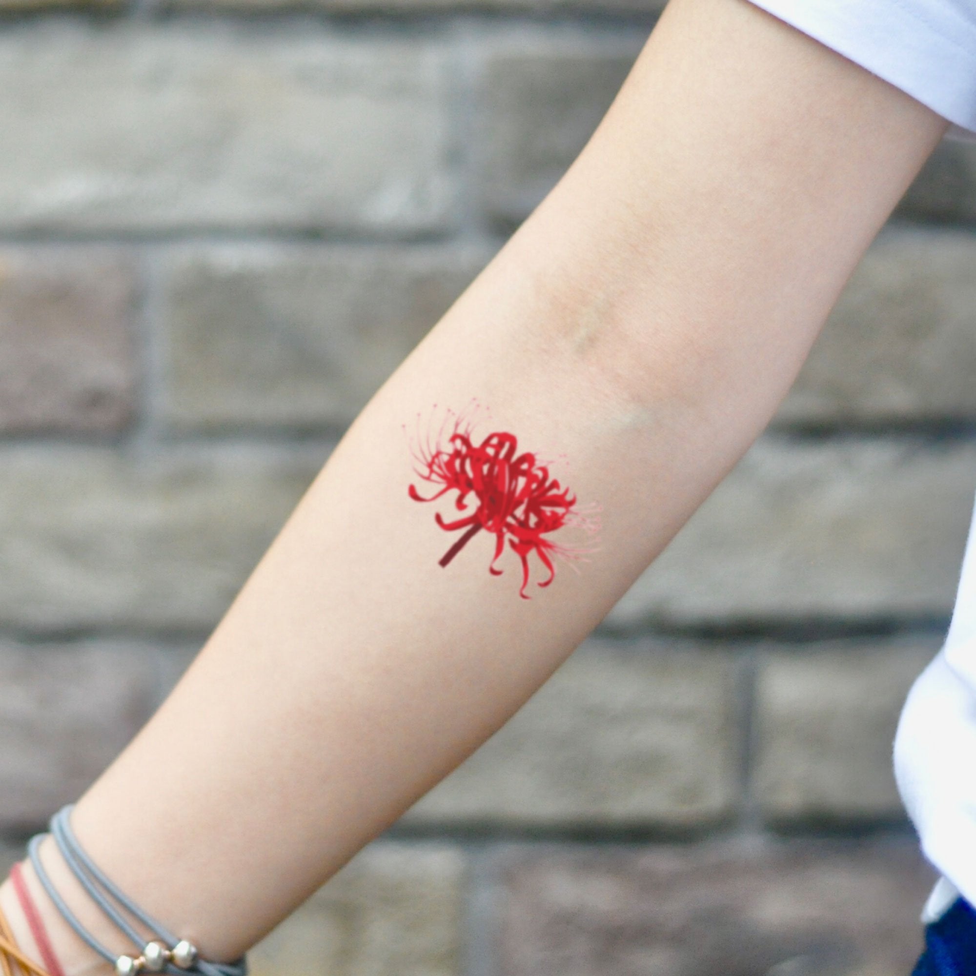 Red Spider Lily tattoo on the inner forearm