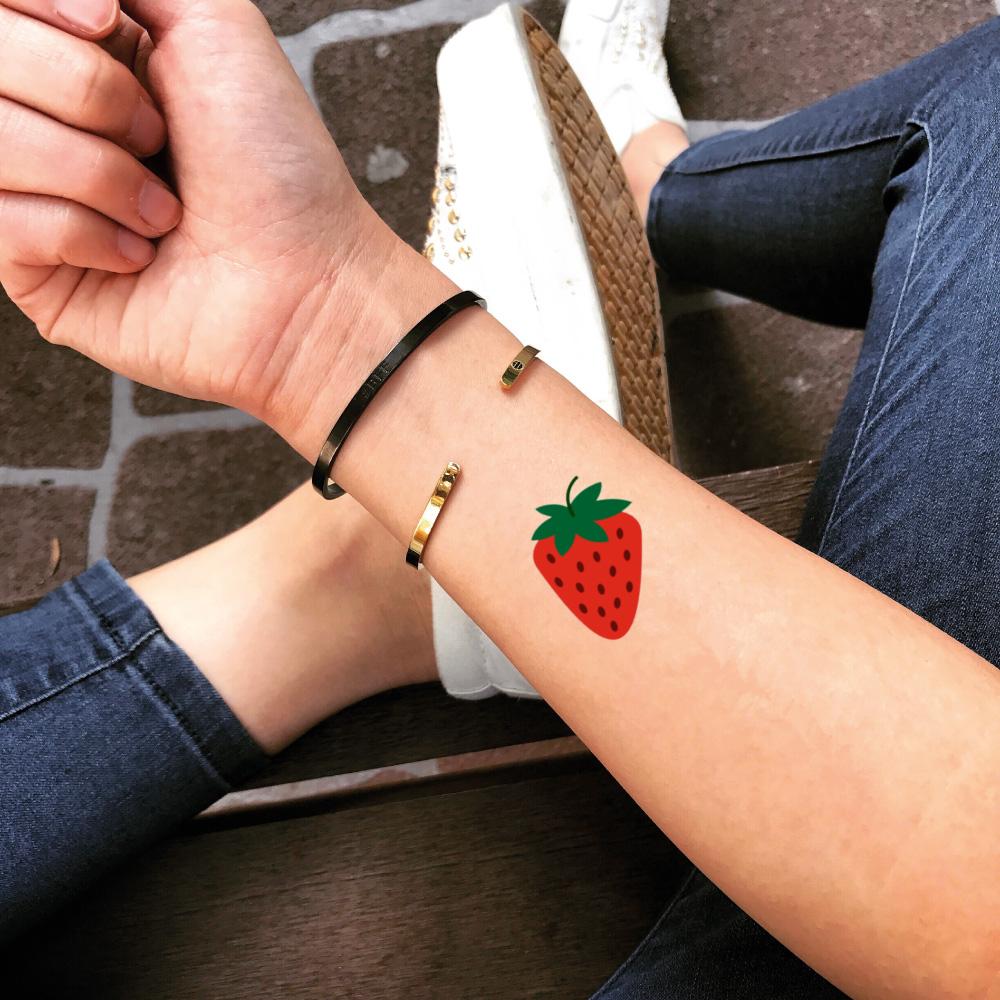 Minimalistic style strawberry tattoo located on the