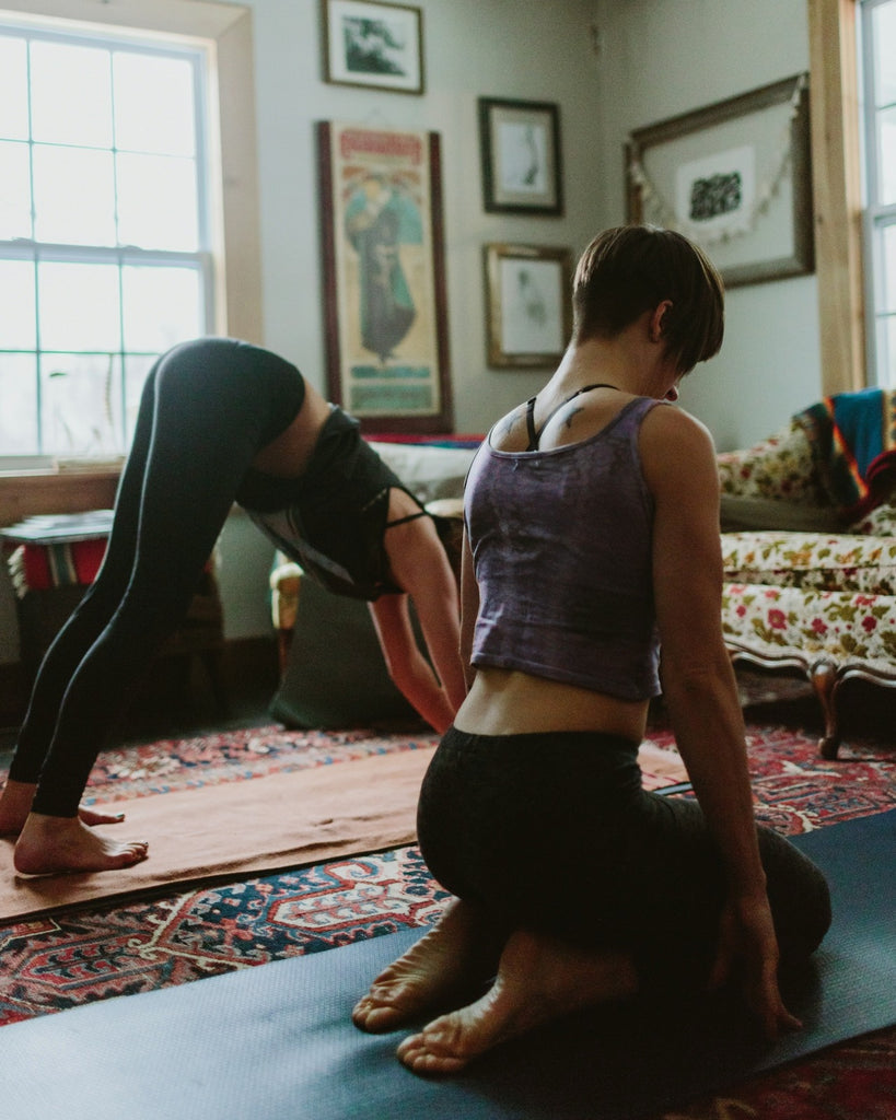 People practising yoga in a gentle home setting. A great practice for your natural wellbeing toolkit