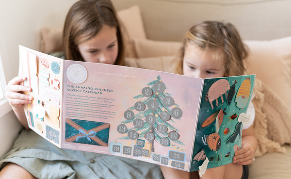 2 kids holing an advent calendar