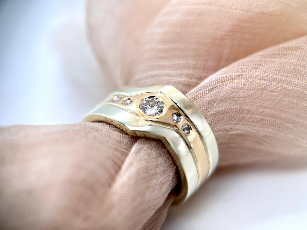 A chunky geometric- shaped ring. The central gold band is set with five diamonds. The outer two white-gold bands create a striking geometric shape.