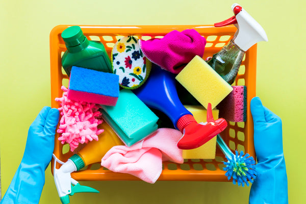 close-up-person-holding-basket-with-cleaning-products