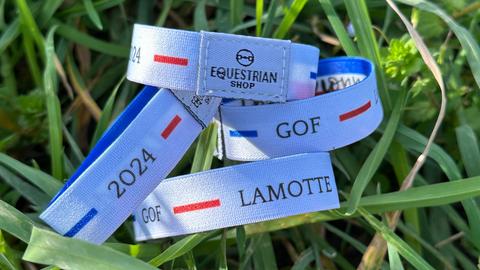 Le bracelet sympbolique des Chazmpionnats de France au Generali open de France une photo des plusieurs bracelet dans l'herbe.