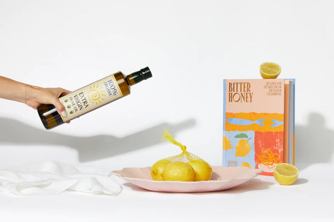 the dinner soiree employee gift set arranged artfully, with a hand pouring the olive oil