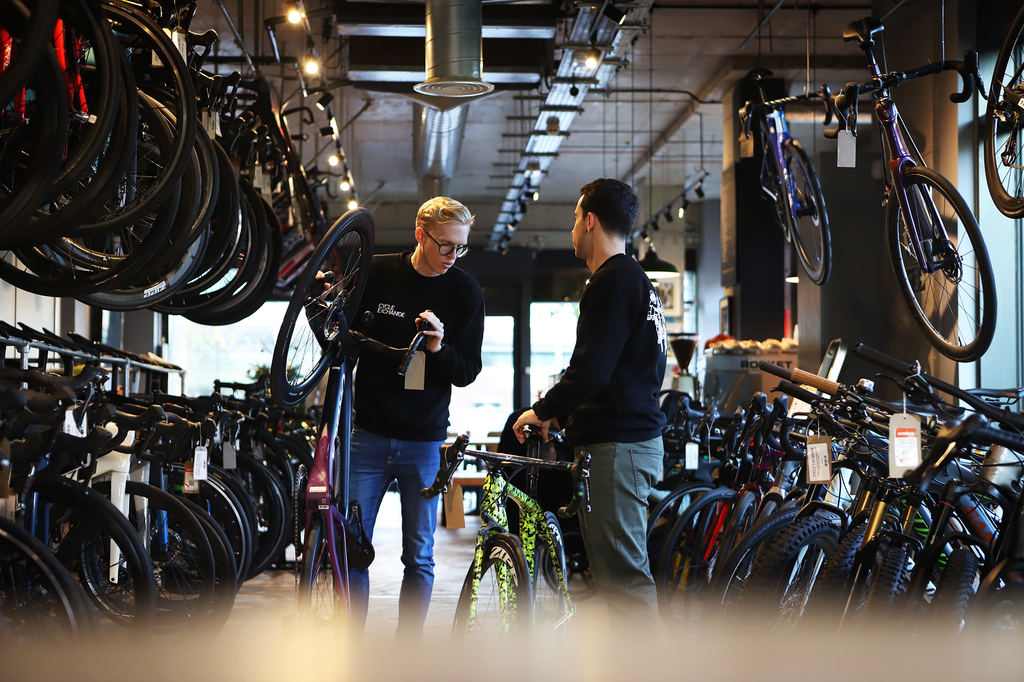 two men talking in a bike shop