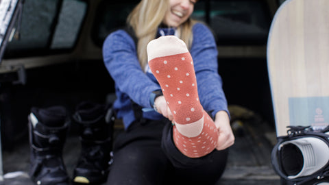 woman putting on merino wool compression socks