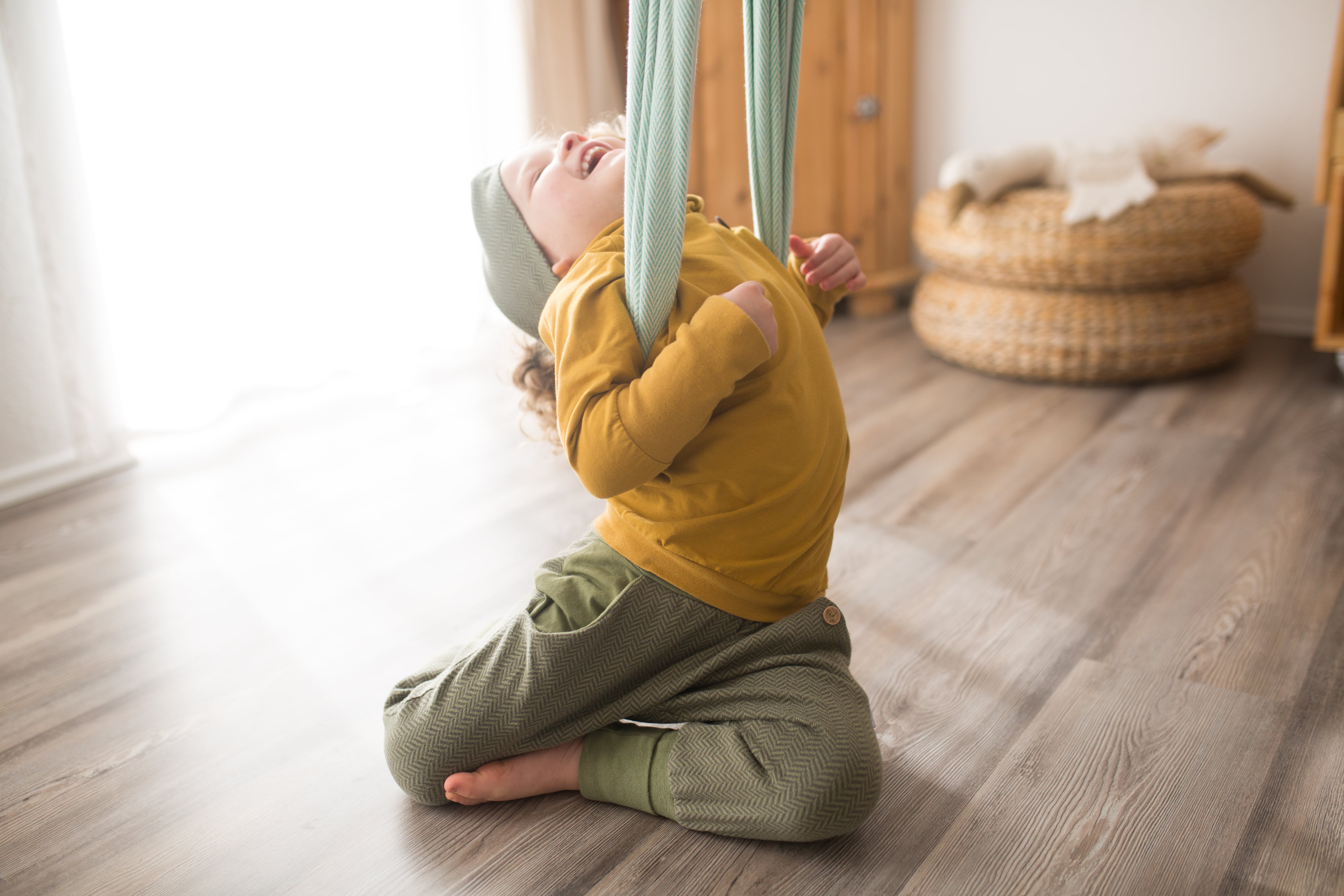 Kind freut sich und trägt nachhaltige Kleidung zum Mitwachsen