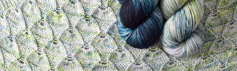 Blue and light green Keira yarn on a knitted background