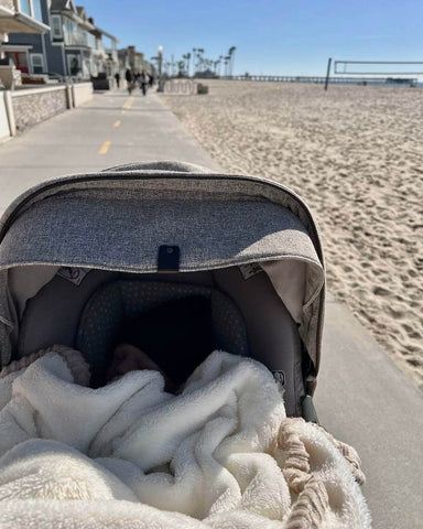 Baby stroller being pushed on a walking trail by the beach