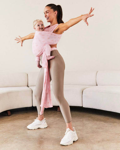 Woman exercising while wearing baby in the Bloom Solly Wrap