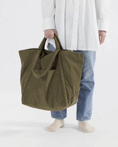 Person holding giant green Baggu tote
