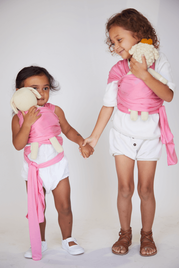 Two young sisters holding hands with their Iconic Pink Solly Dollies