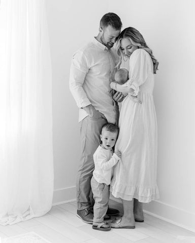 Black and white photo of husband, wife, small child, and baby