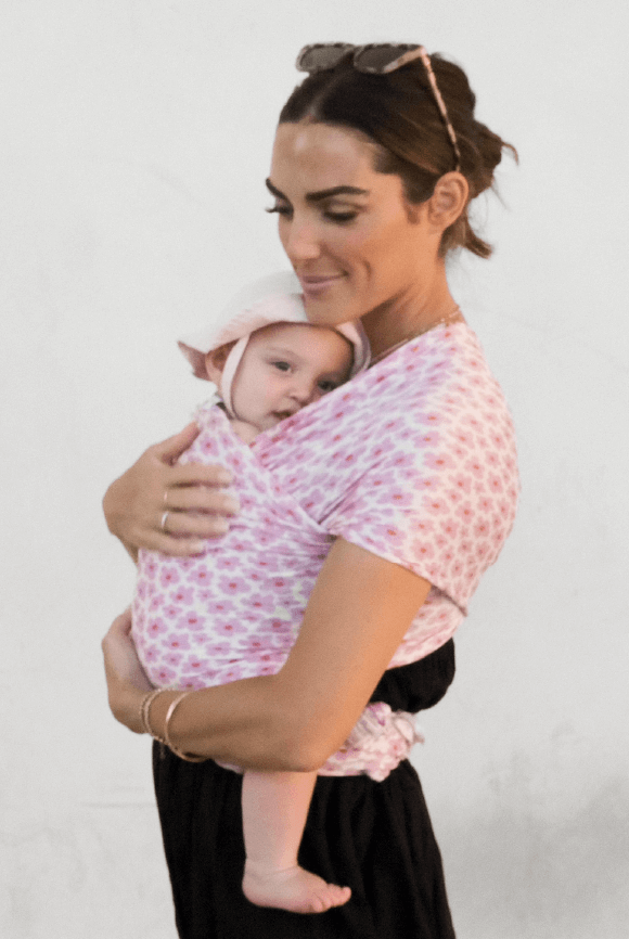 Madi Nelson smiles with arms around her baby in the Ditsy Floral Solly Wrap
