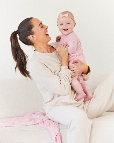 Woman holding baby and smiling at her