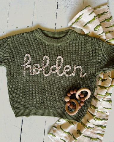 Olive green knit baby sweater, with "Holden" embroidered in cursive