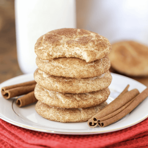 Stack of 5 snickerdoodle cookies on a plate with cinnamon bark