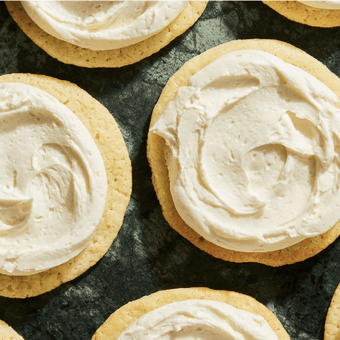 Sugar cookies with buttercream frosting on a green table cloth