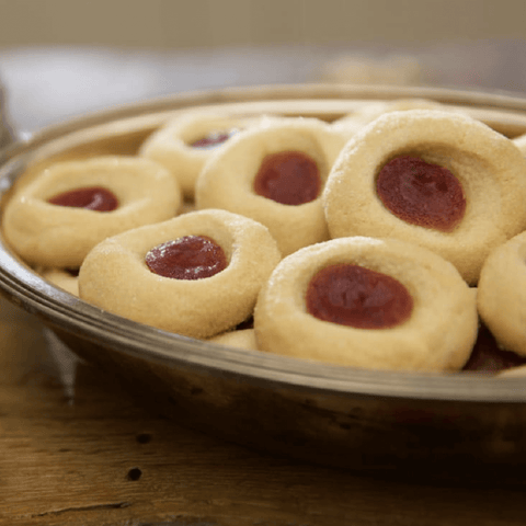 Silver tray of thumbprint butter cookies with fruit jam