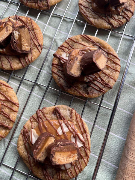 Vegan chocolate and peanut butter cookies cooling on an oven rack.