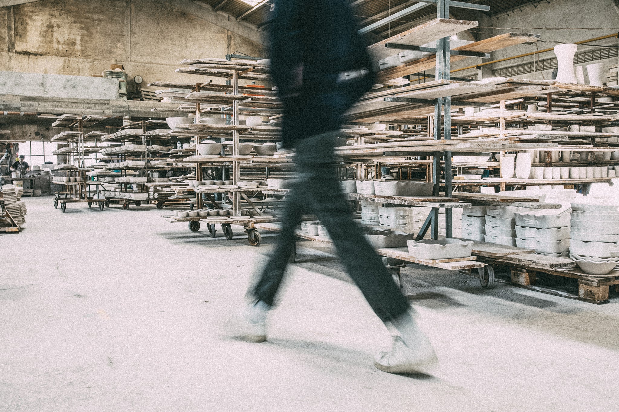 Un homme traverse une usine de céramique