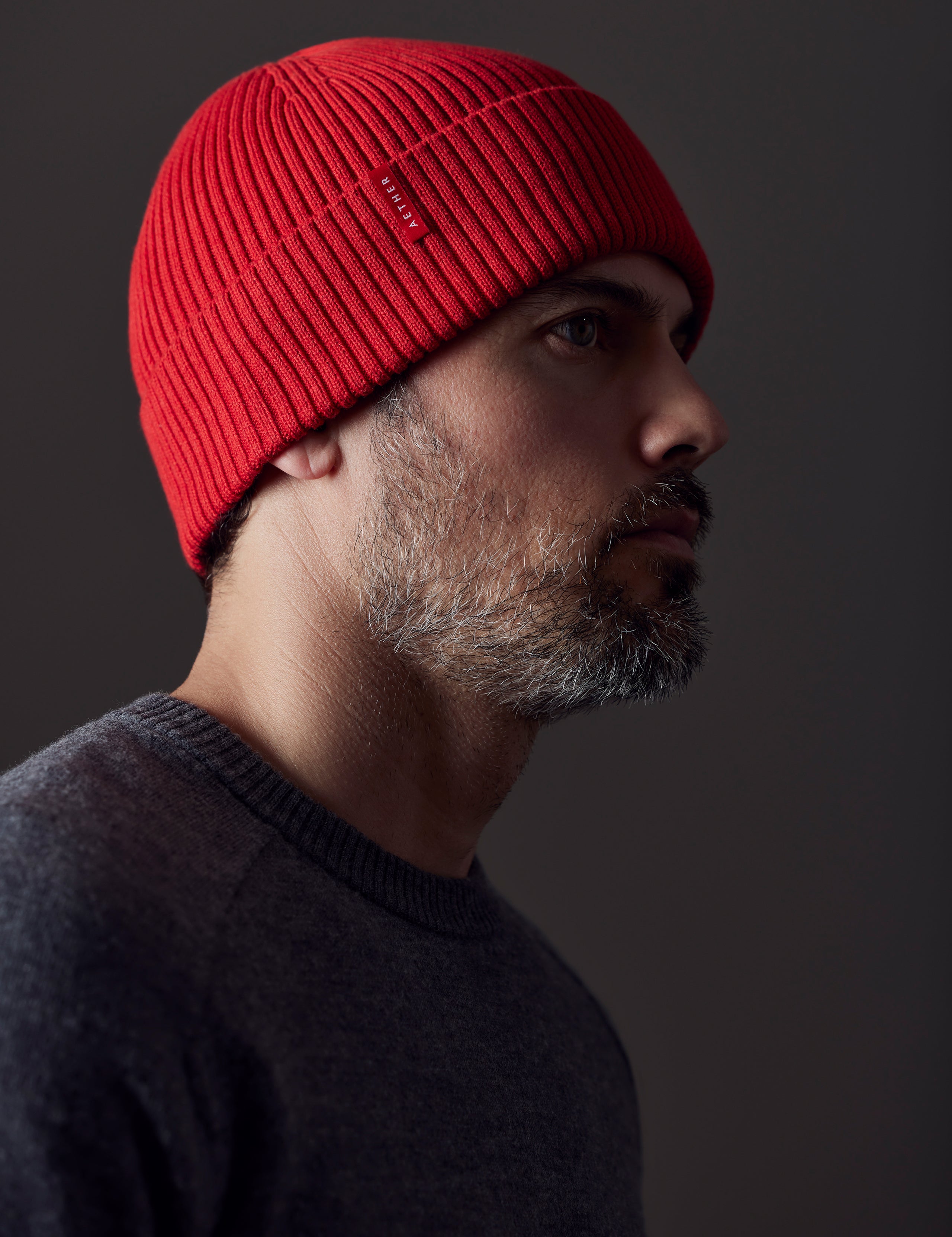 man wearing red cotton beanie from AETHER Apparel
