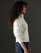 Woman wearing white sweater from AETHER Apparel