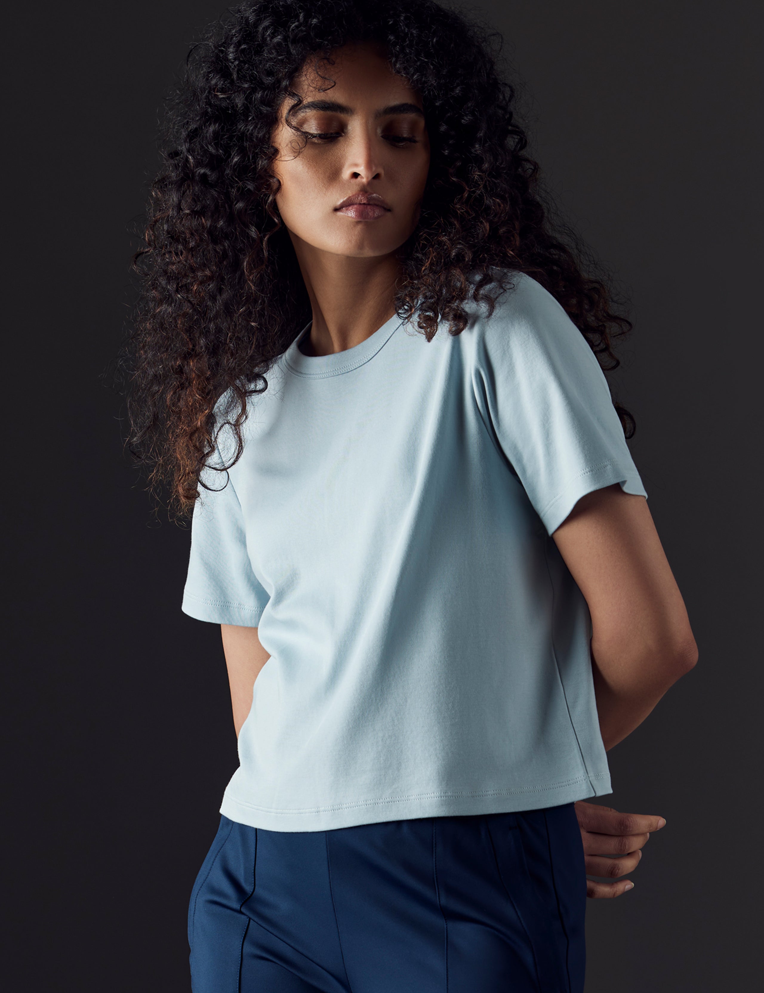 Woman wearing blue organic cropped tee from AETHER Apparel