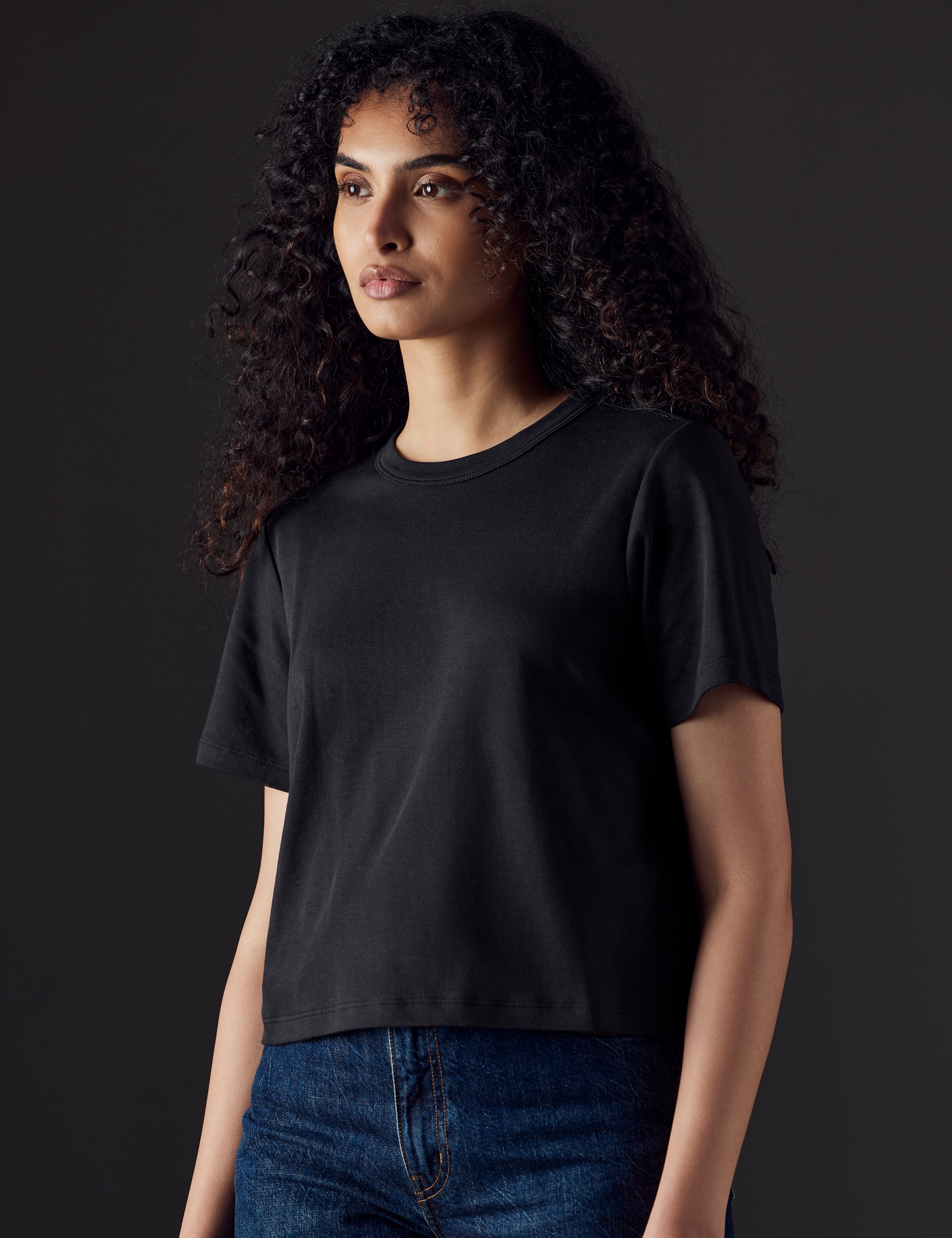 Woman wearing black organic cropped tee from AETHER Apparel