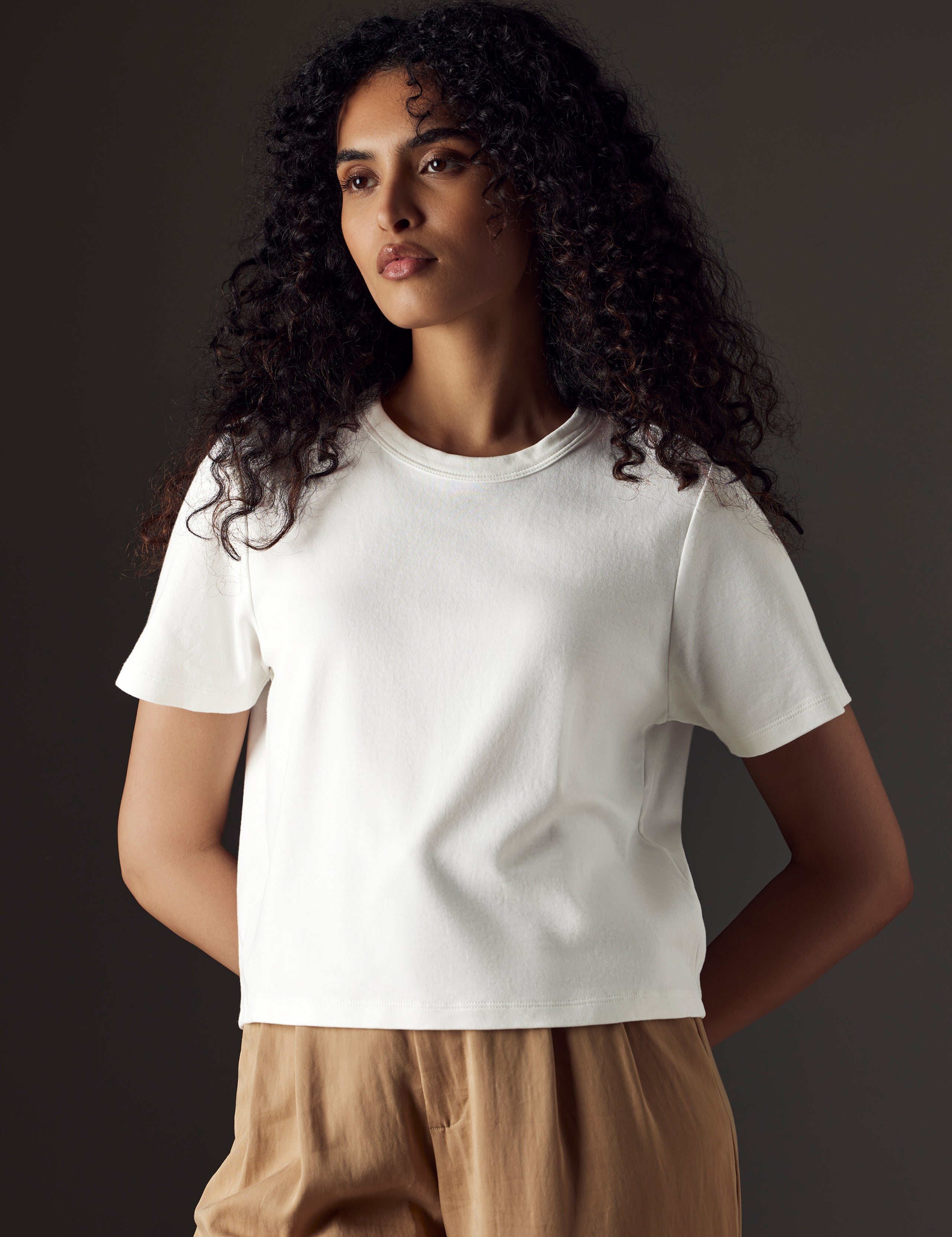 Woman wearing white organic cropped tee from AETHER Apparel