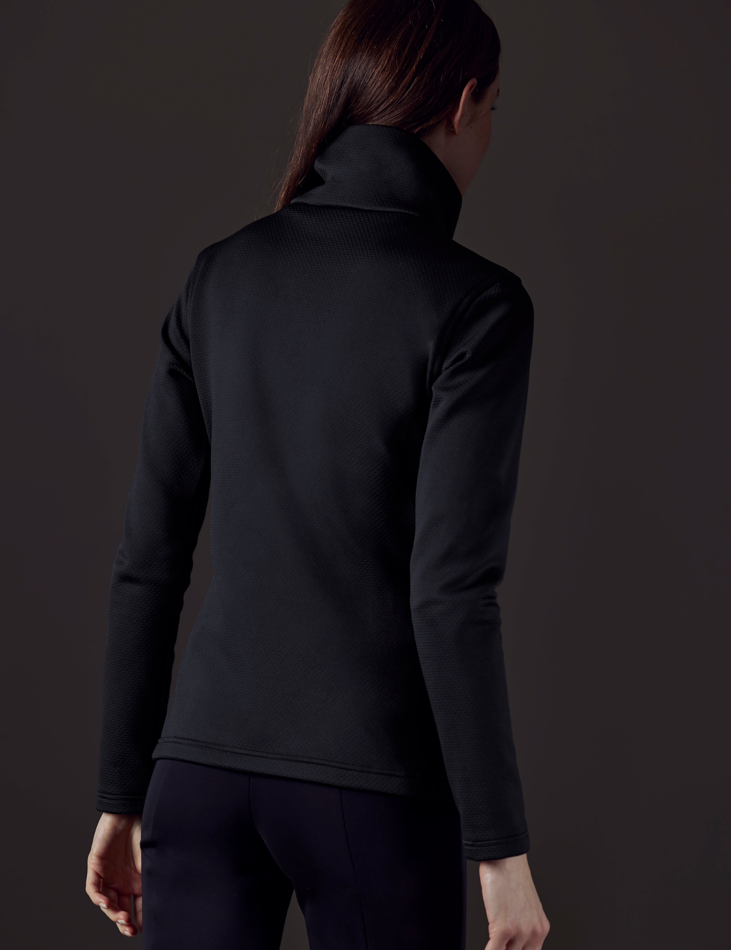 Back view of woman wearing black full-zip from AETHER Apparel