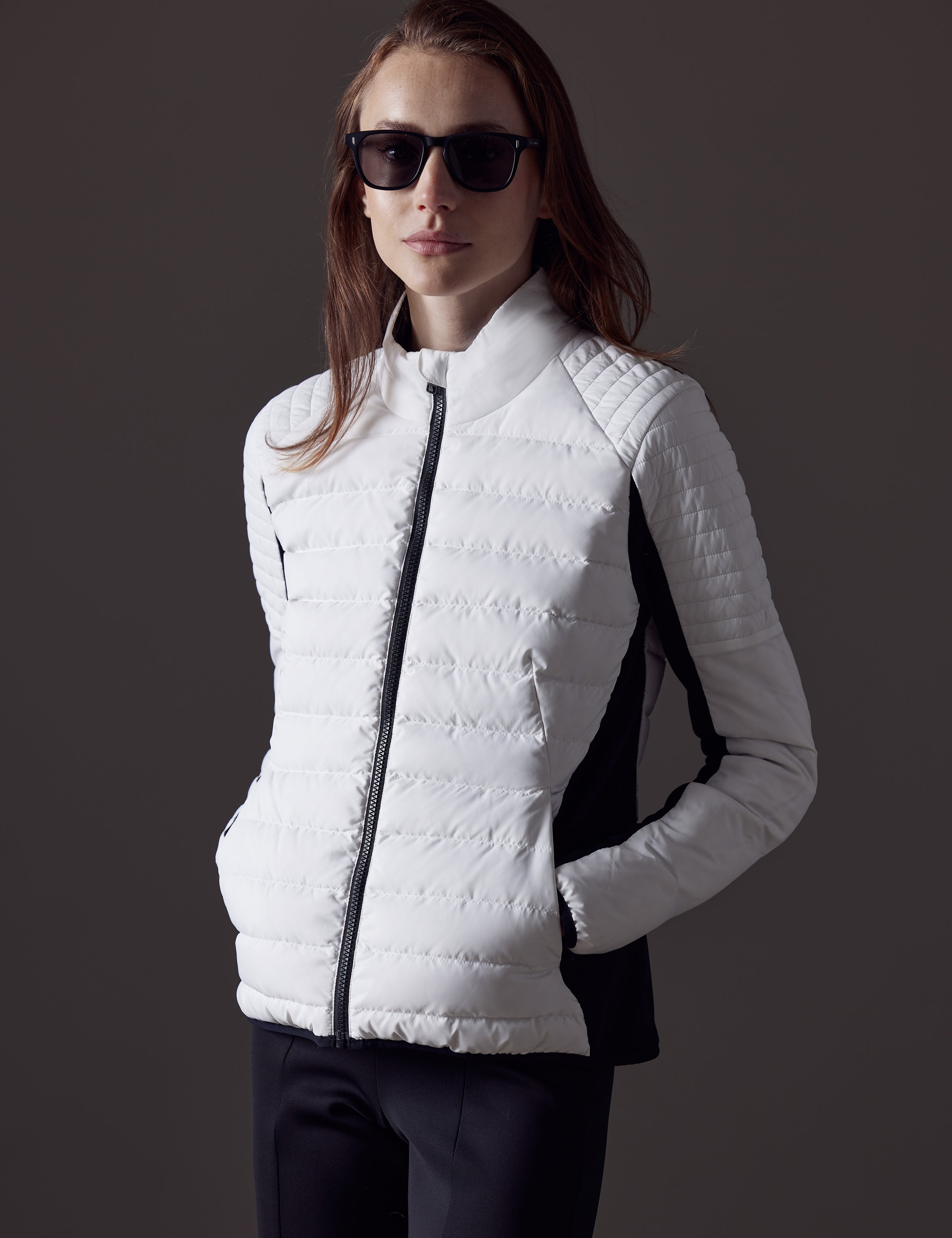 Woman wearing white quilted snow jacket from AETHER Apparel