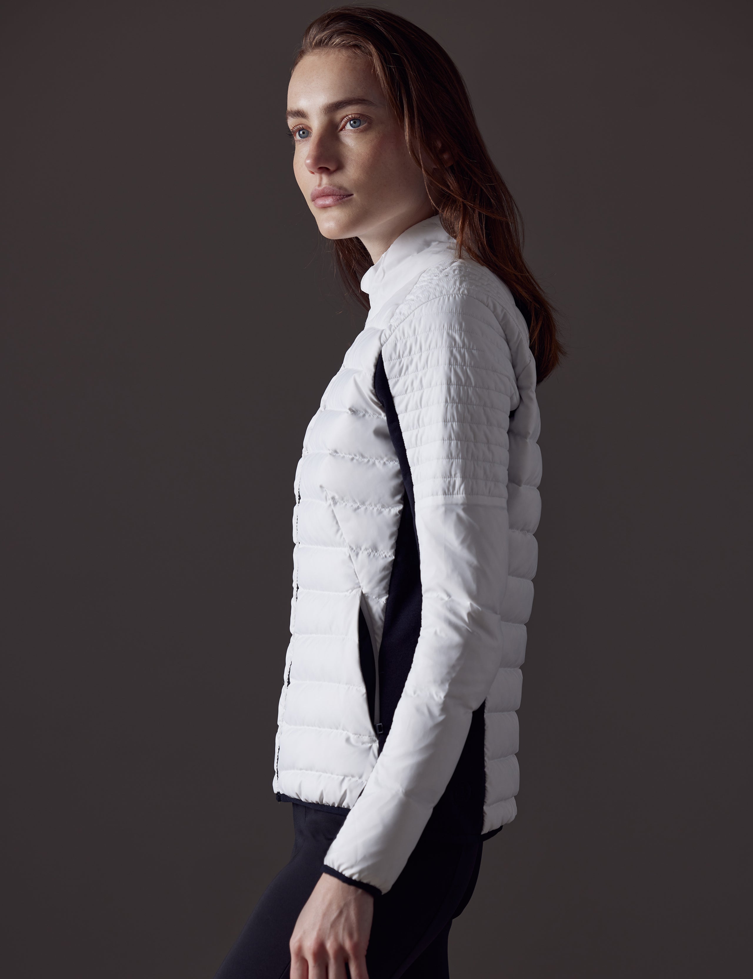 Woman wearing white quilted snow jacket from AETHER Apparel