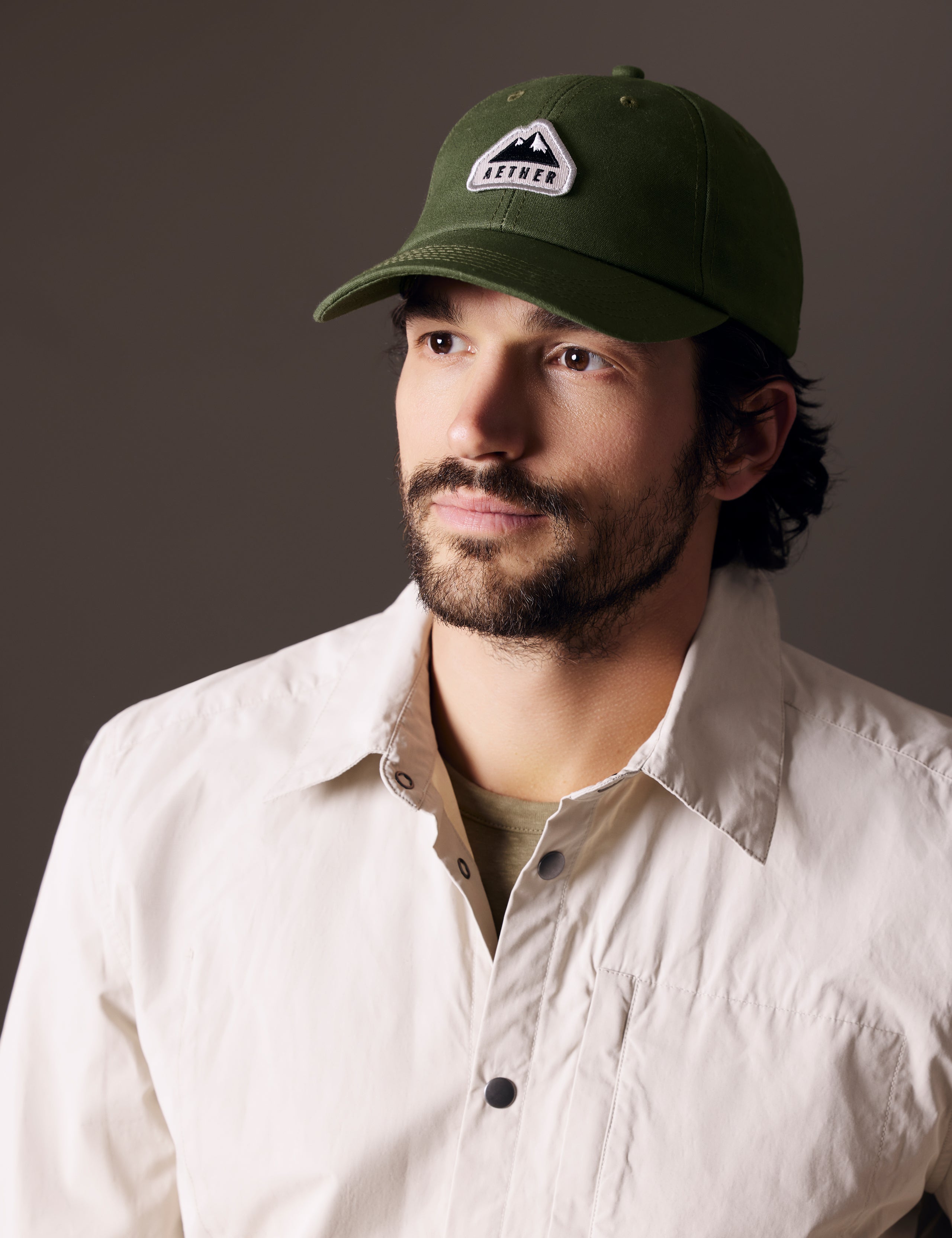 man wearing green AETHER Mountain Hat