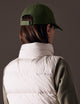 back view of woman wearing green AETHER Mountain Hat