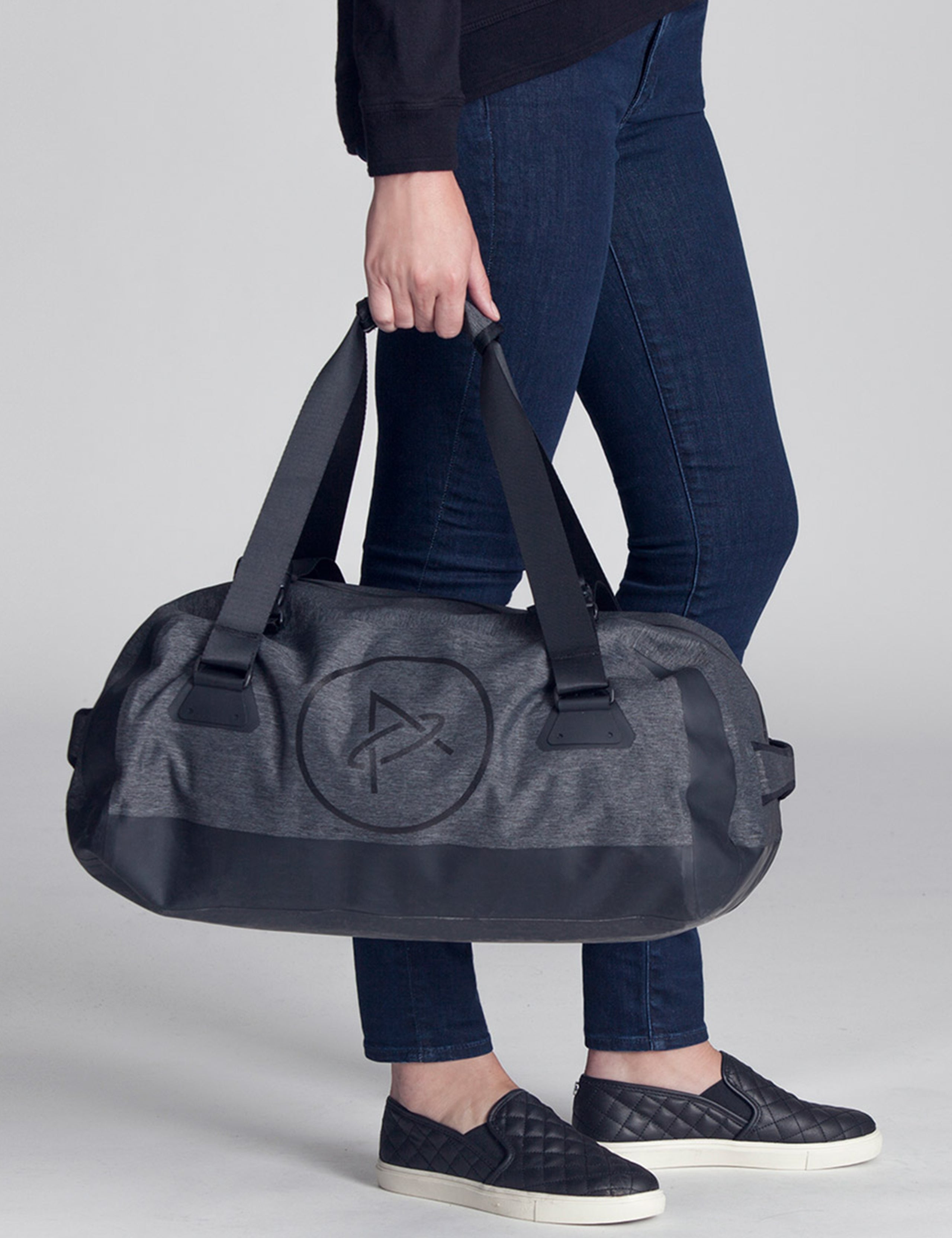 woman holding grey duffle bag from AETHER Apparel
